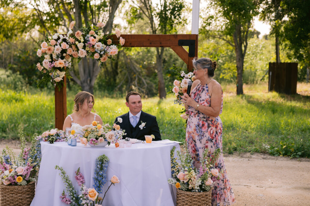 toasts at the sweetheart table under a clear tent